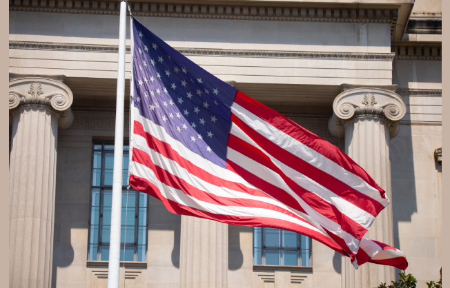 'American flag flying in front of a government building'